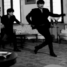 a man in a suit is dancing in a living room