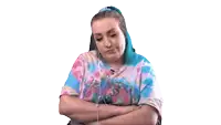 a woman wearing headphones and a tie dye shirt with her arms crossed .