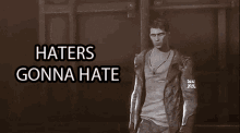 a man in a jacket stands in front of a wall with the words haters gonna hate above him