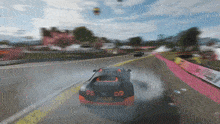 a black and orange sports car is drifting on a road