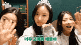 a girl with a tiara on her head is surrounded by other girls