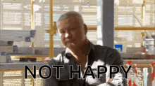 a man is sitting in front of a window with the words not happy written on it
