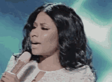a close up of a woman singing into a microphone