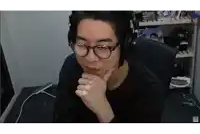 a man wearing glasses and headphones is sitting in a chair with his hand on his chin