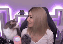 a woman is sitting in a chair with a cat on her lap