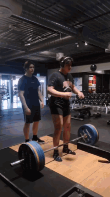 a man wearing headphones is lifting a barbell in a gym with a barbell that says hammer on it