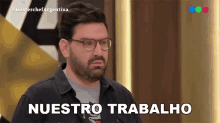 a man wearing glasses says " nuestro trabalho " in spanish