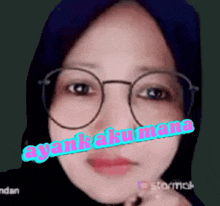 a close up of a woman wearing glasses and a hijab with the words ayah aku mana written on her face