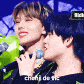 a close up of a person holding a microphone with the name chenji de vic written below them
