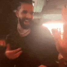 a man with a beard is holding a cell phone and smiling .