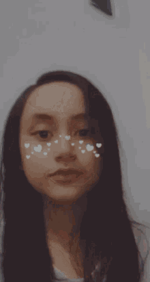 a girl with hearts on her face is smiling