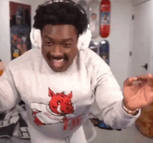 a man wearing headphones and a sweatshirt is dancing in a room .