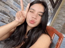 a woman giving a peace sign with her hand