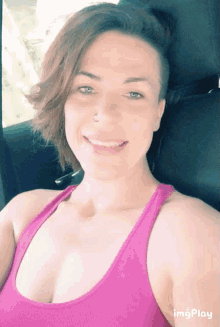 a woman in a pink tank top is smiling for the camera with imgplay below her