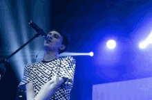 a man is singing into a microphone on a stage .