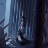 a little girl is sitting on the floor in a dark room with a chair in the background .