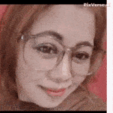 a close up of a woman 's face wearing glasses and smiling .