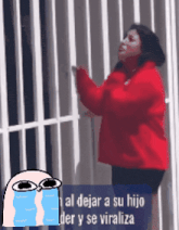 a woman in a red jacket is standing in front of a white fence with a cartoon of her crying