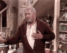 a man in a brown sweater stands in a room