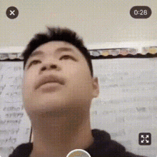 a close up of a man 's face with a white board in the background and a time of 0:28