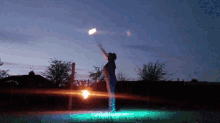 a person is holding a fire torch in the air at night