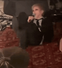 a man in a suit and tie is laying on the floor with his feet up .