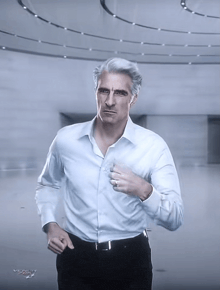 a man in a white shirt and black pants is standing in a hallway