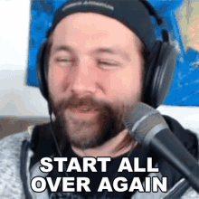 a man with a beard is wearing headphones and a microphone and says `` start all over again '' .