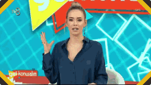 a woman in a blue shirt is talking on a tv show