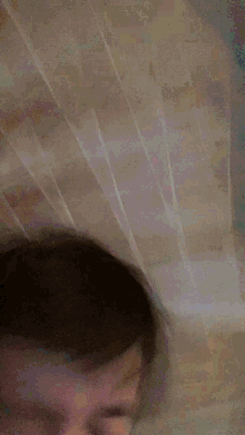 a blurry picture of a person 's face with a blue shirt on