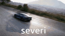 a blue sports car is driving down a road with the word severi on the bottom right