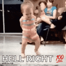 a little girl is dancing in front of a crowd with the words hell right above her .