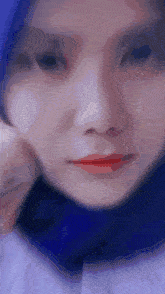 a close up of a woman 's face with a blue head scarf