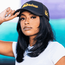 a woman wearing a hat with the word notorious on it