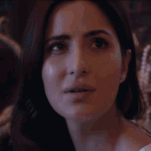 a man is touching a woman 's face while looking at her in a mirror .