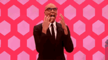 a man in a suit and tie is screaming in front of a pink background with hexagons