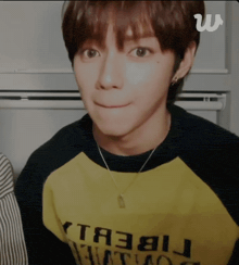 a close up of a person wearing a yellow shirt that says ta3bl