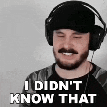 a man with a beard is wearing headphones and smiling .