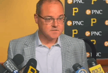 a man wearing glasses stands in front of a sign that says pnc on it