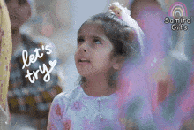 a little girl says let 's try with a rainbow behind her