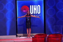 a woman is dancing on a stage in front of a large uno sign