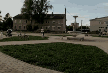a fountain in the middle of a park with a brick walkway