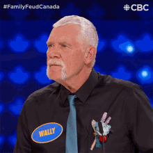 a man wearing a black shirt and tie has a name tag that says wally