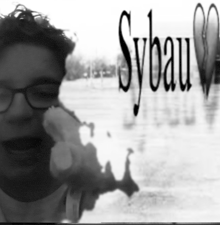 a black and white photo of a man wearing glasses with sybau written in the background