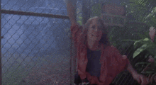a woman is crying in front of a high voltage fence