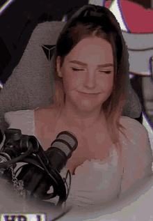a woman is sitting in a chair with her eyes closed and a microphone in her hand .
