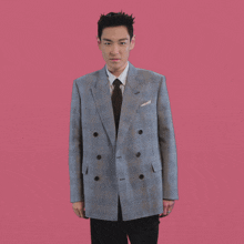 a man in a suit and tie is dancing with his hands in the air