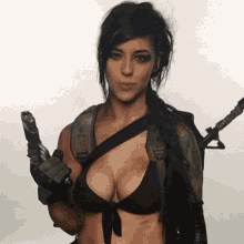 a woman in a bikini is holding a gun in her hand