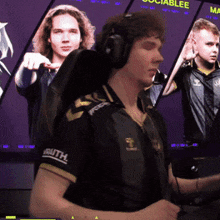 a man wearing headphones is sitting in front of a screen that says ' socialblee ' on it