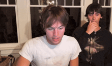 a man wearing a black hoodie with a picture of a bird on it